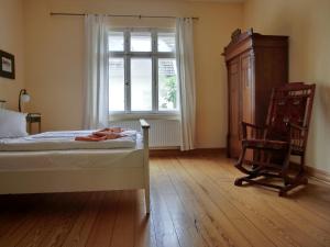 a bedroom with a bed and a chair and a window at Strandstraße 60 Ferienwohnung S12 in Graal-Müritz