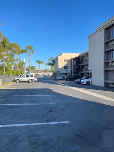 un estacionamiento con autos estacionados frente a un edificio en Hotel Milagro, en Chula Vista