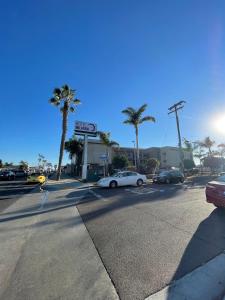 een straat met auto's geparkeerd bij een tankstation met palmbomen bij Hotel Milagro in Chula Vista