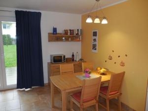 - une salle à manger avec une table et des chaises en bois dans l'établissement Ferienwohnung KWF-4a EG, à Graal-Müritz