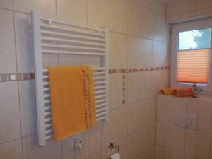 ein Bad mit einer Dusche, einem Handtuch und einem Fenster in der Unterkunft Ferienwohnung KWF-4a EG in Graal-Müritz