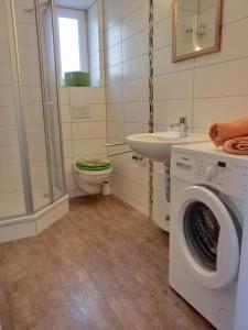 ein Badezimmer mit einer Waschmaschine und einem Waschbecken in der Unterkunft Ferienwohnung KWi 73 EG "grüne Oase" in Graal-Müritz