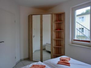 een slaapkamer met een glazen achterdeur met een douche en handdoeken op een bed bij Ferienwohnung KWi 72 EG - "Kleine Fluchten" in Graal-Müritz