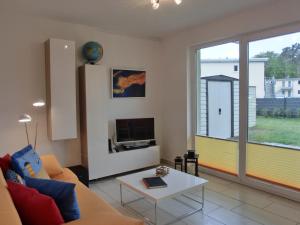 een woonkamer met een bank en een tafel bij Ferienwohnung KWi 72 EG - "Kleine Fluchten" in Graal-Müritz