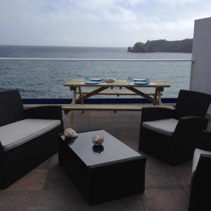 patio ze stołem i krzesłami oraz oceanem w obiekcie Blue House w mieście Vila Franca do Campo