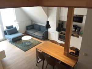 ein Wohnzimmer mit einem blauen Sofa und einem Tisch in der Unterkunft Ferienwohnung H 20 in Graal-Müritz