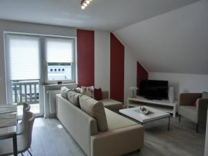 a living room with a couch and a tv at Ferienwohnung P15 in Graal-Müritz