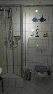 een badkamer met een douche en een toilet bij Ferienwohnung S33 "Leuchtturm" in Graal-Müritz