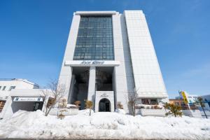 旭川旭川自由宿酒店的一座建筑物前有雪