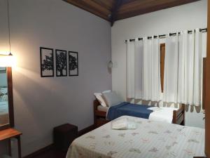 ein Hotelzimmer mit 2 Betten und einem Fenster in der Unterkunft KasaBella Monte Verde in Monte Verde