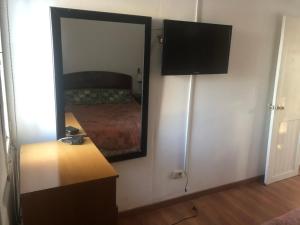 een slaapkamer met een spiegel, een dressoir en een bed bij Apartamento cerca Playa Mansa y centro Maldonado aire acondicionado TV cable, Wifi Netflix in Maldonado