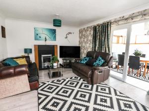a living room with a couch and a television at West Cottage in Forfar