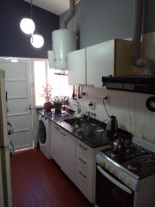 a kitchen with a stove and a washing machine at Confort y tranquilidad al 100% in Malargüe