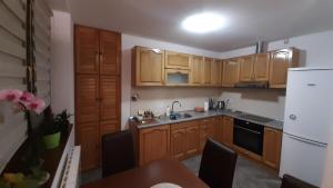- une cuisine avec des placards en bois et un réfrigérateur blanc dans l'établissement Apartment Aurelio, à Zenica