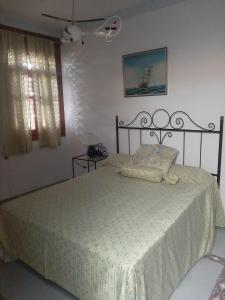 a bedroom with a bed with a white comforter at CASA en el CENTRO DE RONDA in Ronda