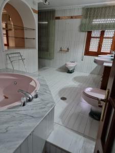 a bathroom with a pink tub and a toilet at CASA en el CENTRO DE RONDA in Ronda