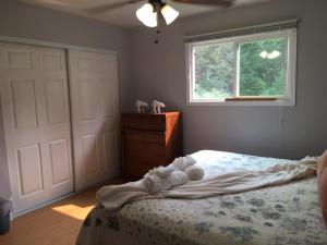 a bedroom with a bed with white sheets and a window at Thunder Mountain Place - Quiet, Comfortable Place Offering DISCOUNT ON TOURS! in Juneau