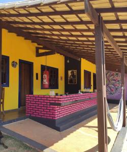 un edificio con pérgola de madera y ladrillos rojos en Das Marias Hostel en Lagoa Santa