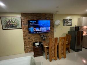 una cucina e una sala da pranzo con TV su un muro di mattoni di Cozy Studio Hotel-like Condominium at Megatower Residences a Baguio