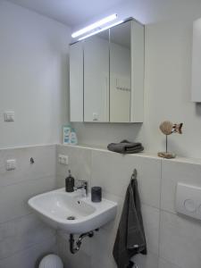 Baño blanco con lavabo y espejo en Ferienwohnung KWi 84 EG en Graal-Müritz