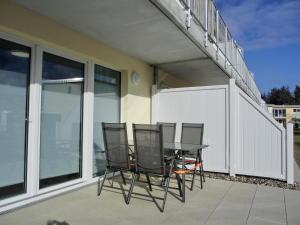 eine Terrasse mit 4 Stühlen und einem Tisch auf dem Balkon in der Unterkunft Ferienwohnung KWi 84 EG in Graal-Müritz