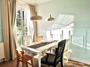 une salle à manger avec une table et des chaises blanches dans l'établissement Ferienwohnung i34, à Graal-Müritz