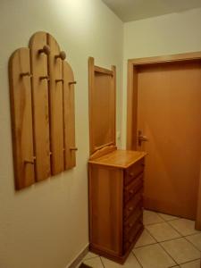 ein Umkleideraum mit einem Holzschrank und einer Tür in der Unterkunft Ferienwohnung E1 in Graal-Müritz