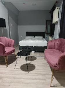 um quarto com uma cama, 2 cadeiras e uma mesa em paşa konağı konaklama em Ancara