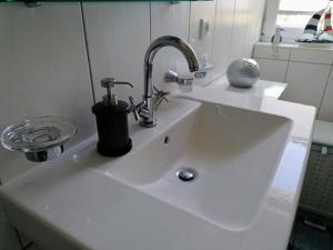 a white sink with a faucet on it at Ferienwohnung M31 "Die Welle" in Graal-Müritz