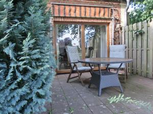 a patio with a table and chairs next to a christmas tree at Ferienwohnung NH6 in Hirschburg