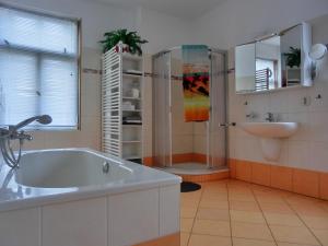 a bathroom with a tub and a sink at Ferienwohnung NH6 in Hirschburg