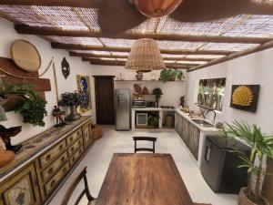 eine Küche mit einem Holztisch im Zimmer in der Unterkunft Nossa Casa Caraíva - A melhor localização da Vila in Caraíva