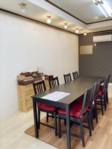 een vergaderzaal met een zwarte tafel en stoelen bij Nishioi House in Tokyo
