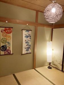 een kamer met een lamp en schilderijen aan de muur bij Nishioi House in Tokyo