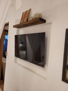TV de pantalla plana colgada en la pared en Nossa Casa Caraíva - A melhor localização da Vila, en Caraíva