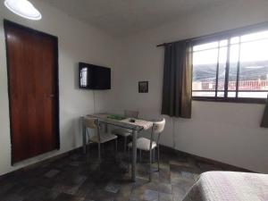 Habitación con mesa, sillas y ventana en Alojamiento Entero con Excelente Ubicación en Morón