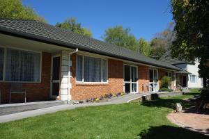uma casa de tijolos vermelhos com relva em Northwood Motor Lodge em Christchurch