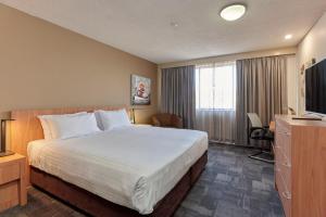 a hotel room with a bed and a television at Best Western Plus Launceston in Launceston