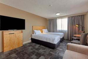 a hotel room with a large bed and a television at Best Western Plus Launceston in Launceston