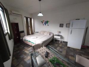 a small bedroom with a bed and a refrigerator at Alojamiento Entero con Excelente Ubicación in Morón