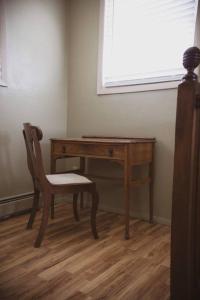 a wooden desk with a chair next to a window at Old School Lodge in Montrose