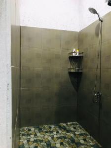 a shower with a glass door in a bathroom at Saung Rancage Batukaras in Pangandaran