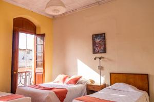 a bedroom with two beds and a window at Casona Jerusalen in Arequipa