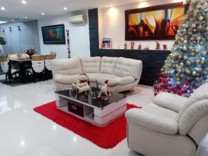 a living room with a christmas tree and white furniture at Casa Boutique HNP in Barrancabermeja