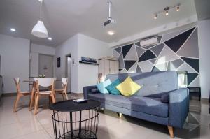 ein Wohnzimmer mit einem blauen Sofa und einem Tisch in der Unterkunft KL Arte Plus @ Jalan Ampang by IdealHub in Kuala Lumpur