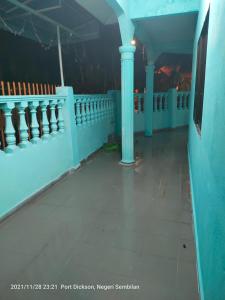 a hallway of a building with blue walls and columns at Teratak Port Dickson Homestay Mus Only in Port Dickson