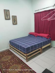 łóżko w pokoju z czerwoną zasłoną w obiekcie Teratak Port Dickson Homestay Mus Only w mieście Port Dickson