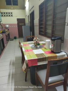 een tafel in een keuken met een tafelkleed erop bij Teratak Port Dickson Homestay Mus Only in Port Dickson