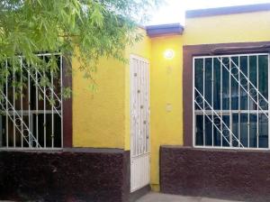 un edificio amarillo con puerta y puerta en Casa Vicky Alojamiento para vacaciones y trámites consulares, en Ciudad Juárez