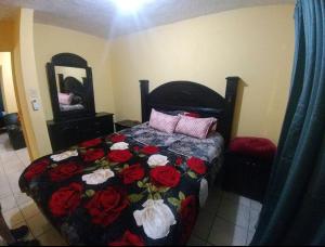 Un dormitorio con una cama con rosas rojas. en Casa Vicky Alojamiento para vacaciones y trámites consulares, en Ciudad Juárez